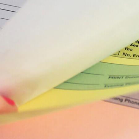 person thumbing through multipart form of Nekoosa digital carbonless paper