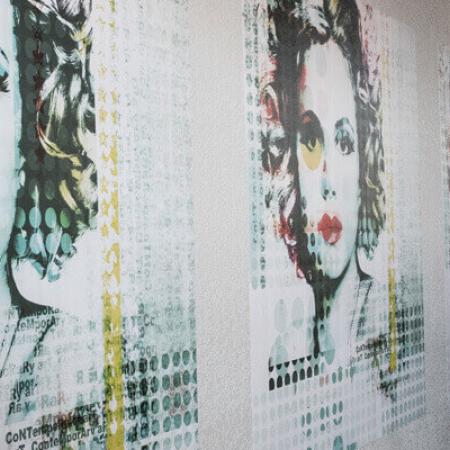woman installing three woman's face vinyl wall graphics using Nekoosa removable vinyl film